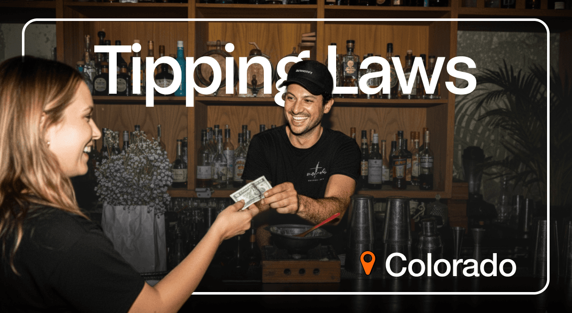 Smiling bartender receiving tip in Colorado bar.