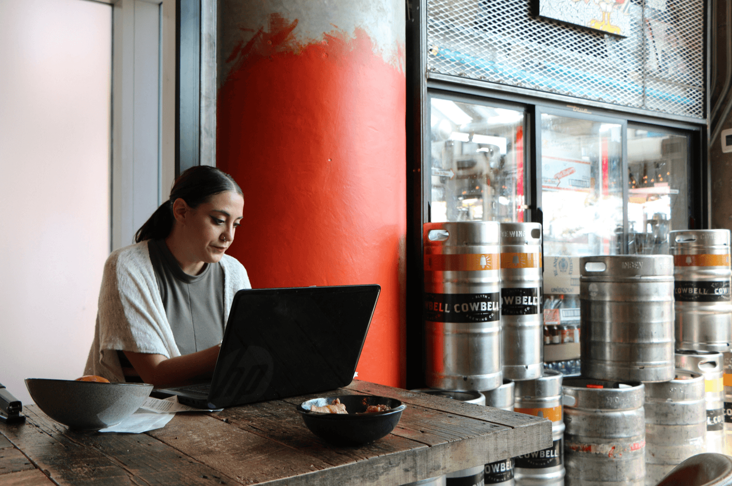 Woman working on laptop in brewery cafe