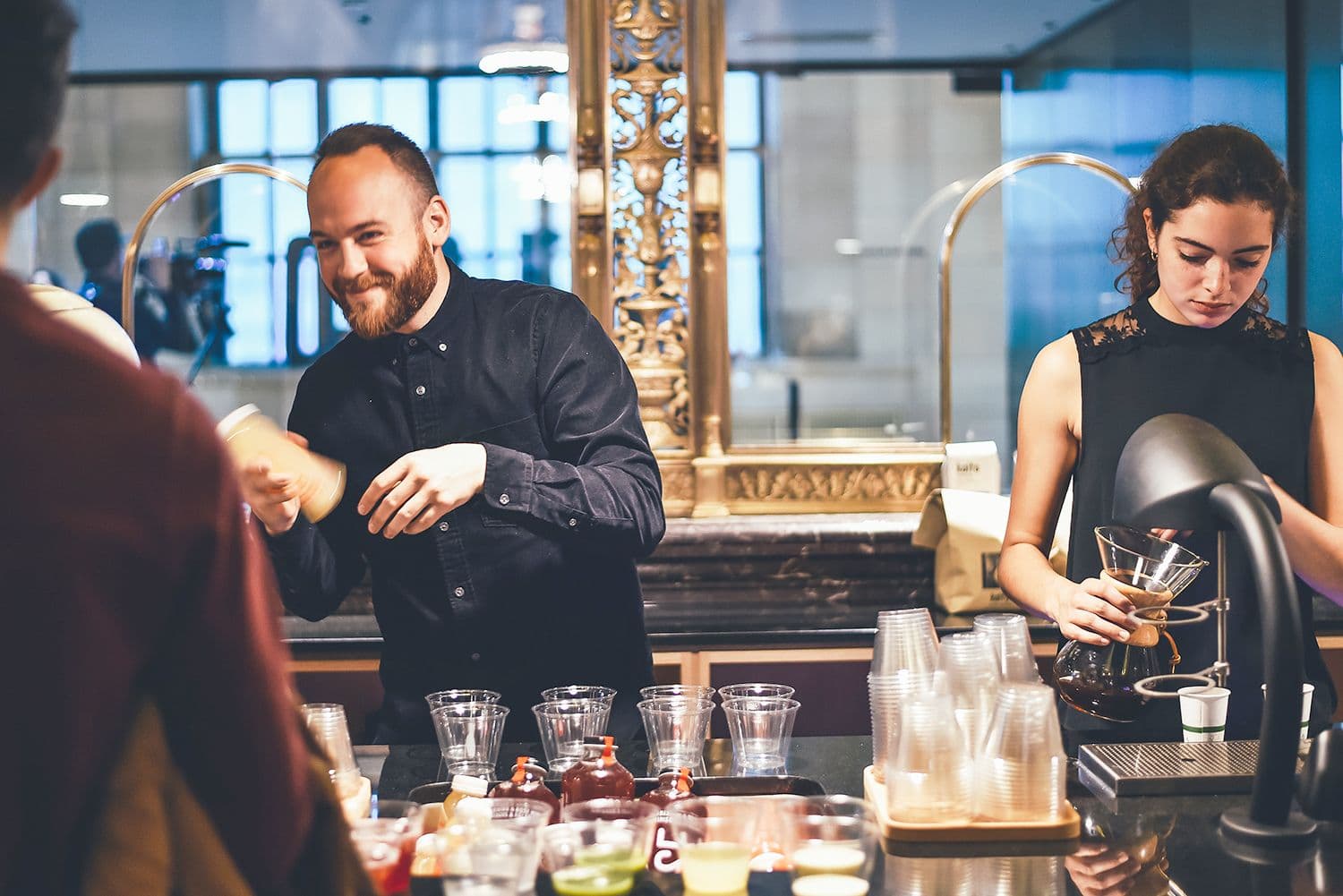 Baristas preparing coffee drinks at a café