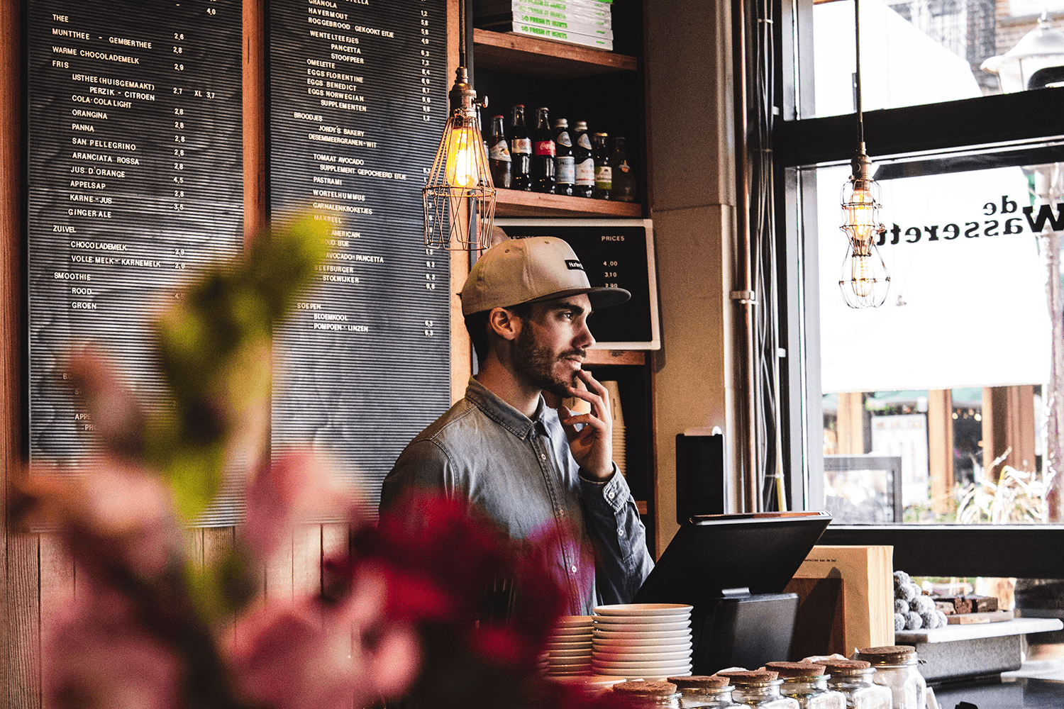 Barista contemplating menu in cozy cafe.
