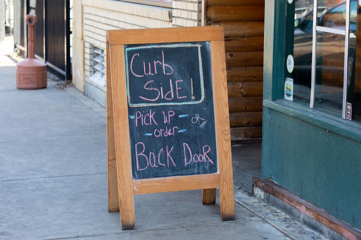 Chalkboard sign for curbside pickup at restaurant.
