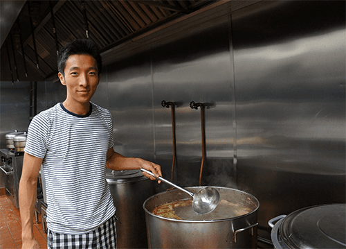 Chef cooking soup in industrial kitchen