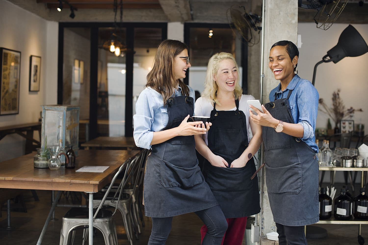 Baristas laughing and chatting in a cafe