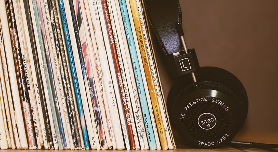 Vinyl records and headphones on a shelf.