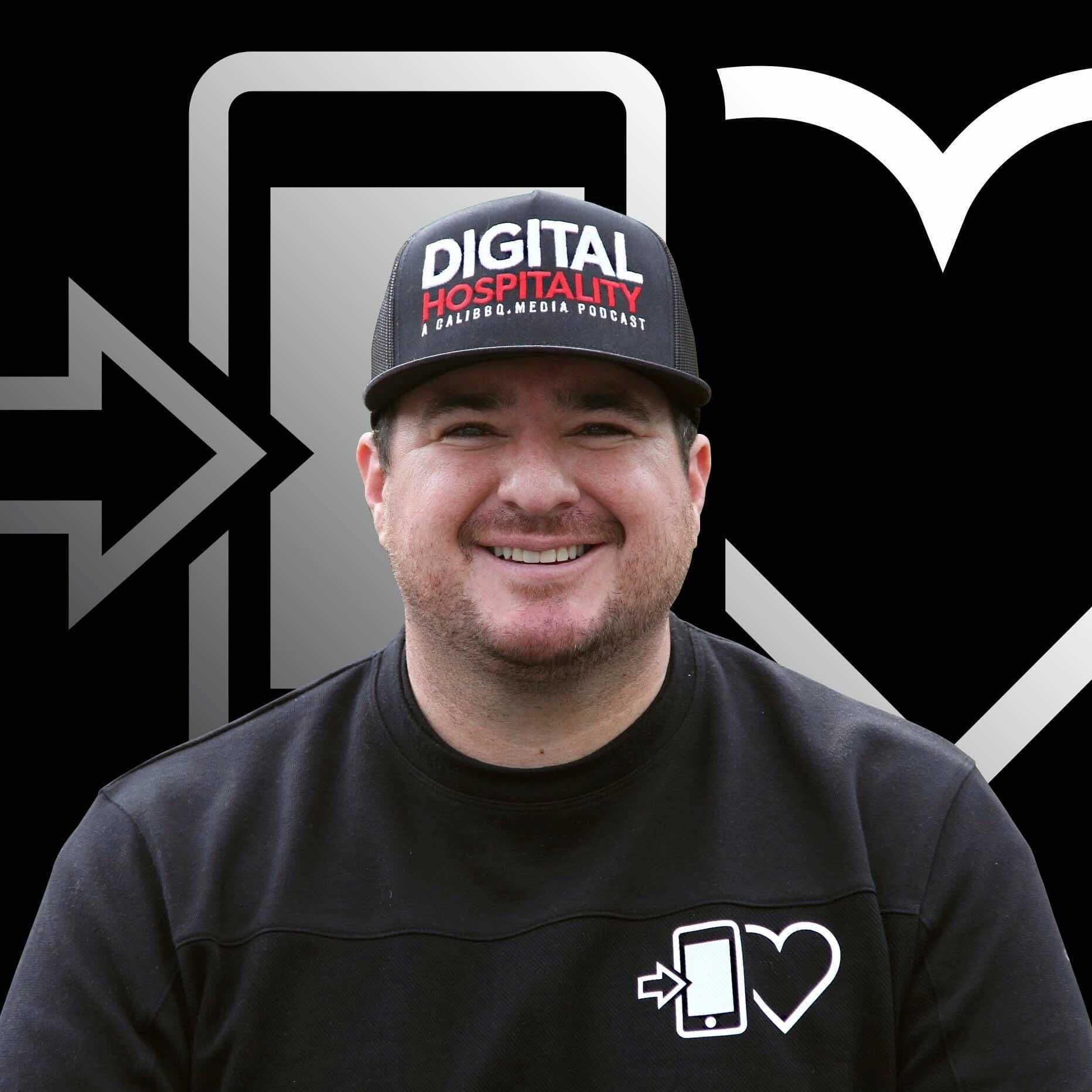 Person smiling wearing 'Digital Hospitality' cap, black background.