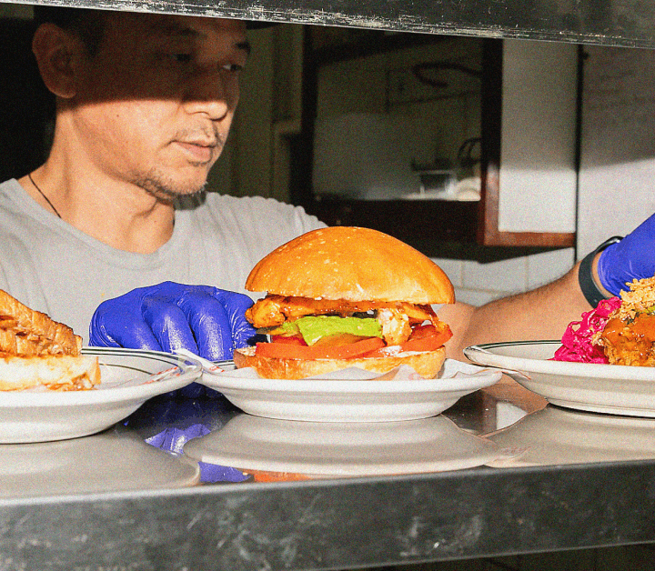 Chef plating gourmet burgers in kitchen